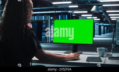 Professional Mature Female Heavy Industry Engineer Works on Green Mock-up Screen Computer. Professional Programming in a High Tech Development Laboratory Concept Stock Photo