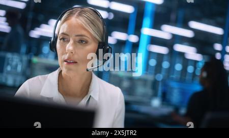 Busy Caucasian Woman Customer Service Support Agent in Headset Talking with Client and Looking at the Screen while Working at Call Center. Manager on Conference Video Call Consulting Client Online Stock Photo