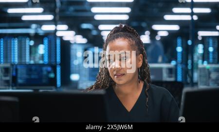 Diverse Office: Enthusiastic IT Programmer Working on Two Desktop Computers. Female Specialist Creating Innovative Software. Engineer Developing App, Program, Video Game, Writing Code Stock Photo