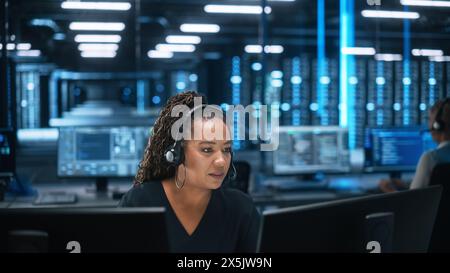 Female Executive Wears Headset Video Calling on Computer at Evening Office. Call Center Agent, Service Support Manager Speaking to Distance Customer in Webcam Chat. Helpline Concept Stock Photo