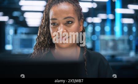 Portrait of Multiracial Female IT Developer Working on Desktop in Data Center. System Administrator Works on Web Services, Cloud Computing, Server Analytics, Cyber Security Maintenance Concept Stock Photo