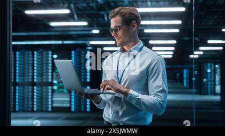Successful Creative Director Working on Laptop Computer in Big City Office Late in the Evening. Male Business Analyst Preparing for a Meeting Discussion About Project Management Report. Stock Photo