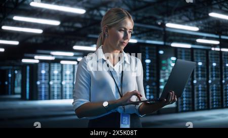 Technology, Progress, Innovation and IT Business Concept. Female European Specialist Using Laptop Computer for High Speed Data and Server Transfer in Big Data Center Office Stock Photo