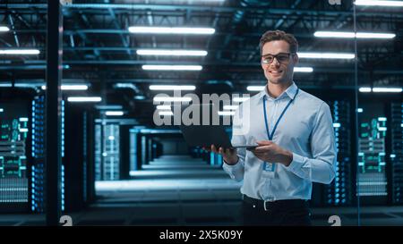 Successful Data Center IT Specialist Using Laptop Computer. Server Farm Cloud Computing Facility with System Administrator Working. Data Protection Engineering Network for Cyber Security. Stock Photo