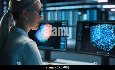 Portrait of Female Technical Operator Works with Display Showing Neural Network In the System Control Dark Room. Caucasian IT Technician Works on Artificial Intelligence. Big Data Scientific Research. Stock Photo