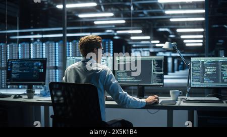 In the System Control Room Technical Operator Sits and Monitors Various Activities Showing on Multiple Displays with Graphics. Responsibility for Information Security in the Company Concept Stock Photo