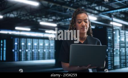 Office: Successful Businesswoman in Stylish Clothes Working on Laptop and Looking at the Screen. Stylish Female Executive Working Late on Computer to Achieve Best Results Stock Photo