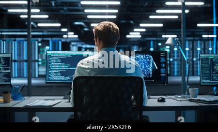 Professional IT Programer Working in Data Center on Desktop Computer with Two Displays, Doing Development of Software and Hardware. Displays Show Blockchain. Data Network Architecture Concept Stock Photo