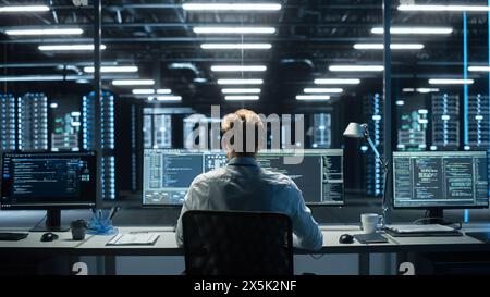 Information Technology Specialist and Data Center Administrator Working on Personal Computer, Monitoring Web Services, Cloud Computing, Analytics Facility, Performing Maintenance and Cyber Security Stock Photo