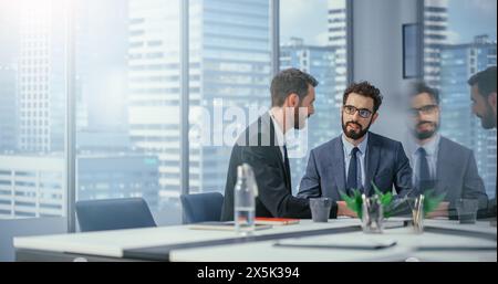 Businesspeople in Modern Office: Business Meeting of Two Businessmen Talking. CEO and Executive Director Working on Digital e-Commerce Project. Planning, Finding Solutions. Stylish Reflection Shot Stock Photo