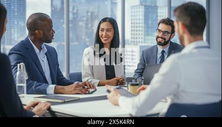 Multi-Ethnic Office Conference Room Meeting: Diverse Team of Top Managers, Executives, Share Digital Tablet Computer Talk. Businesspeople Discuss Strategy, do Analysis. Stock Photo