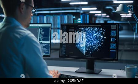 Technical Operator Works at His Workstation with Display Showing Neural Network In the System Control Room. IT Technician Works on Artificial Intelligence, Big Data Research Facility Stock Photo