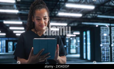 Server Farm Cloud. Computing Specialist Facility with Multiethnic Female System Administrator Working with Data Protection Network for Cyber Security. Data Center Engineer Using Tablet Computer. Stock Photo