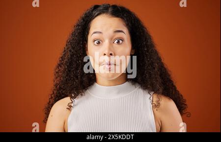 African woman, portrait and studio with fish lips for comedy, gesture with face or comic. Female comedian, brown background and surprise with sucking Stock Photo