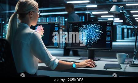View Over the Shoulder of International Computer Scientist Develop Neural Network at her Workstation. Office with Computer with Functioning AI and Neural Data Infographics Stock Photo