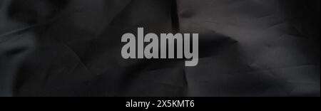 Black crinkled wavy woven material background with a dark dramatic textured surface. Web design banner size Stock Photo