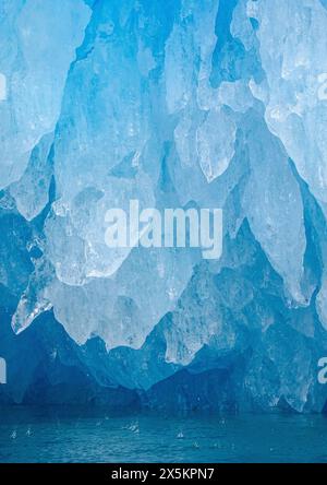 Iceberg in the fjord with melt structure. landscape in the Johan Petersen Fjord, a branch of the Sermilik Icefjord, Ammassalik region, Greenland, Danish Territory. Stock Photo