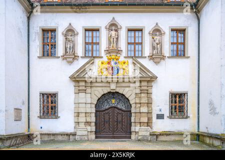 Ornate entrance door of the Old Chateau in Bad Muskau, adorned with statues and a colorful coat of arms. Saxony, Germany Stock Photo