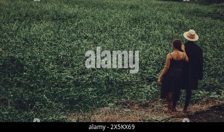 Nigeria, Delta state, Rear view of stylish couple standing in field Stock Photo