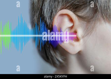 ear closeup, child listening, sound wave, acoustics and sound vibrations, Auditory System, Hearing Test, Cochlear implant, Assistive listening device Stock Photo