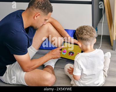 Father and son using digital tablet at home Stock Photo