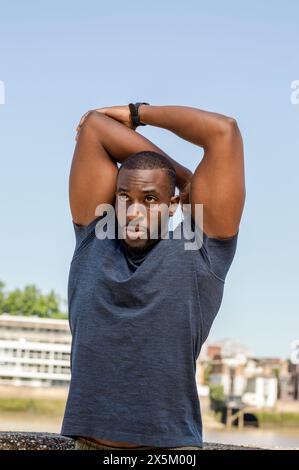 Mid adult man stretching in urban setting Stock Photo