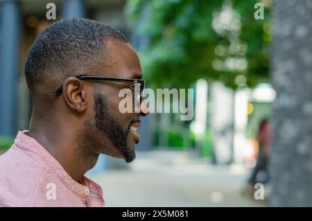 Outdoor profile of smiling man wearing glasses Stock Photo