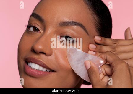 Studio portrait of beautiful woman applying under eye patch Stock Photo