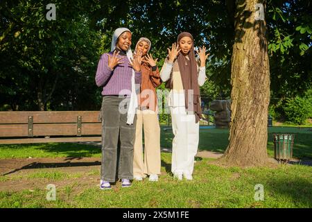 UK, London, Portrait of three young women wearing hijabs in park Stock Photo