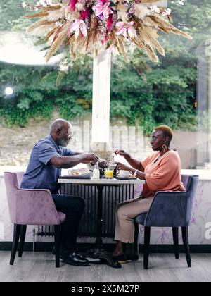 UK, Mature couple enjoying breakfast in hotel Stock Photo