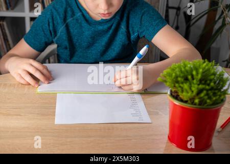 schoolchild doing homework, copying words English, child writes in notebook, assignments involving English language exercises, acquisition, vocabulary Stock Photo