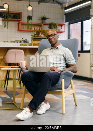 Man using laptop in office cafeteria Stock Photo