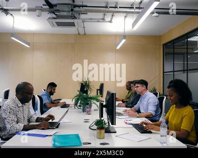 Office workers using computers in co-working office space Stock Photo