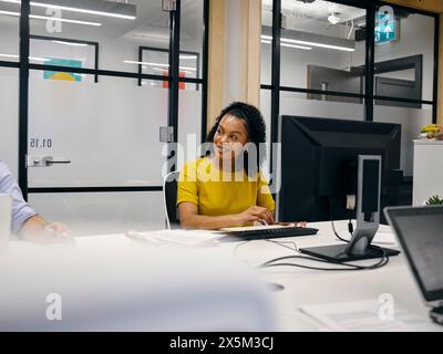 Office workers using computers in co-working office space Stock Photo