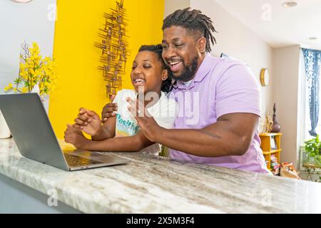 Father and daughter using laptop at home Stock Photo