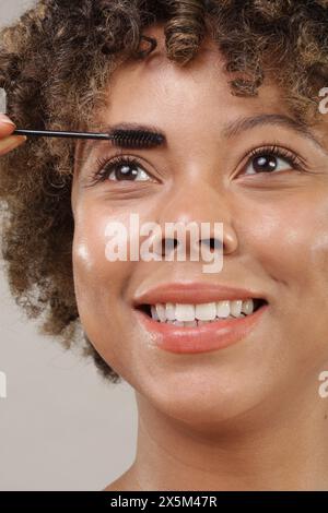 Studio shot of woman applying mascara, close up Stock Photo