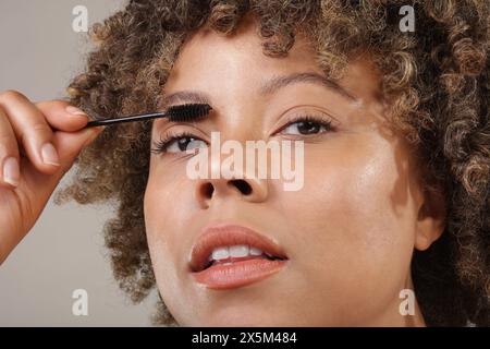 Studio shot of woman applying mascara, close up Stock Photo