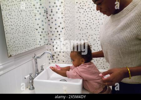 Mother and daughter washing hands in bathroom Stock Photo