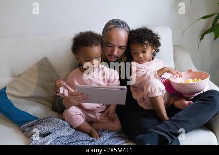 Father with daughters using digital tablet Stock Photo