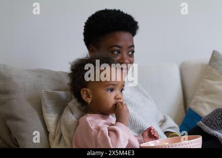 Mother and daughter sitting on sofa Stock Photo