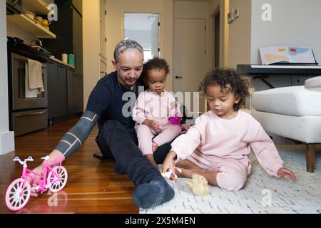 Father playing with daughters at home Stock Photo