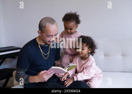 Father reading with daughters Stock Photo