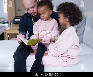 Father reading with daughters Stock Photo