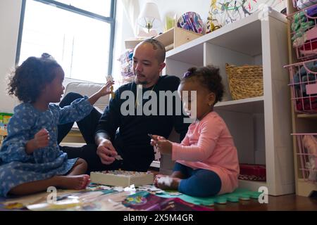 Father and daughters playing at home Stock Photo