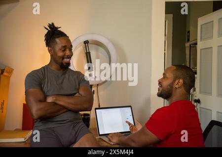 Smiling male couple working from home Stock Photo