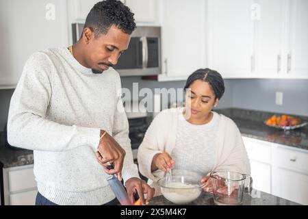 Couple preparing food in kitchen Stock Photo
