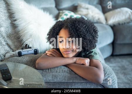 Boy lying on sofa in living room Stock Photo