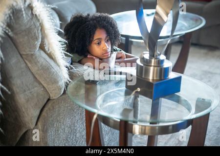 Boy lying on sofa in living room Stock Photo