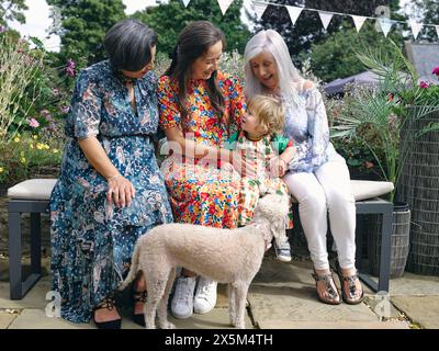 Multi-generation family with baby boy sitting on bench Stock Photo