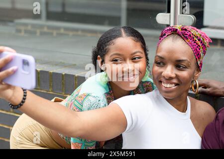 Smiling friends taking selfie outdoors Stock Photo
